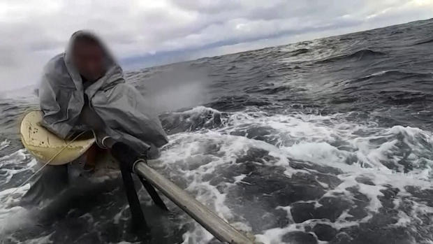 An image capture from video shows a man being rescued by Japan's coast guard after he drifted in choppy waters for nearly a day. 