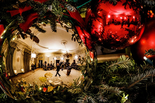 President Joe Biden reflected in Christmas tree ornaments at the White House 