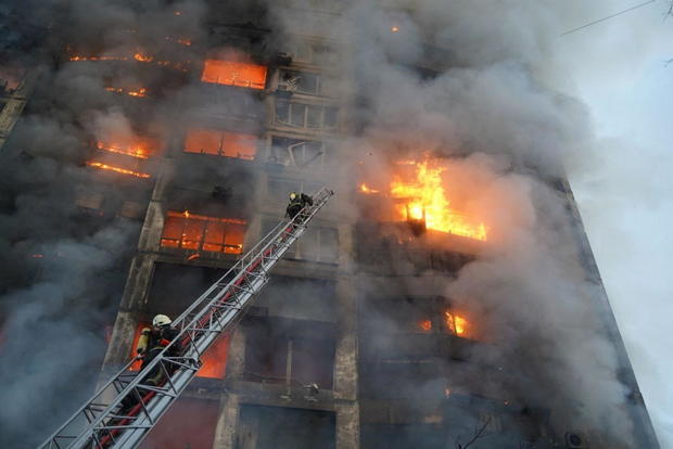 Rescuers work next to a residential building damaged by shelling in Kyiv 