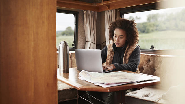 Woman using laptop while sitting in camper van 