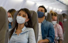 Woman traveling by plane wearing a facemask 