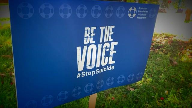 A yard sign from the American Foundation for Suicide Prevention reads, "Be the Voice. #StopSuicide." 