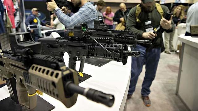 Attendees view Israel Weapon Industries rifles at the company's booth during the National Rifle Association 2019 annual meeting. 